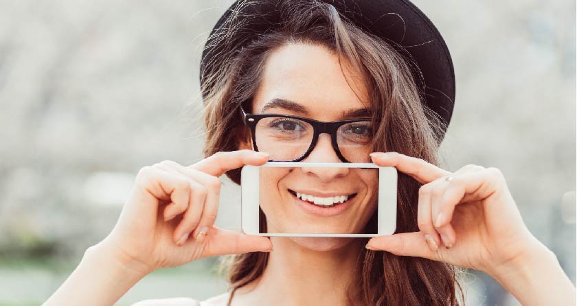 woman holding up smartphone with smile