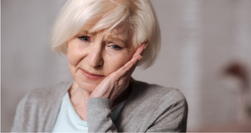 older woman holding her jaw in pain