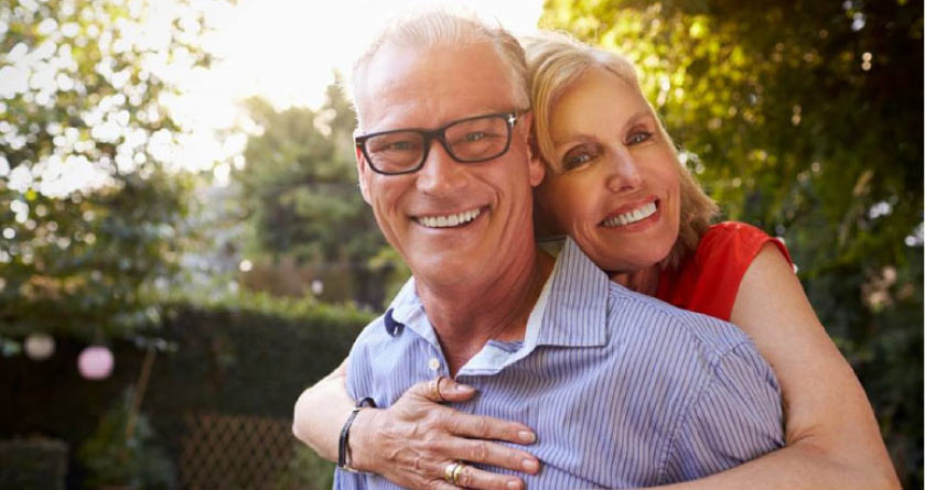 older couple hugging after learning about dental implant options