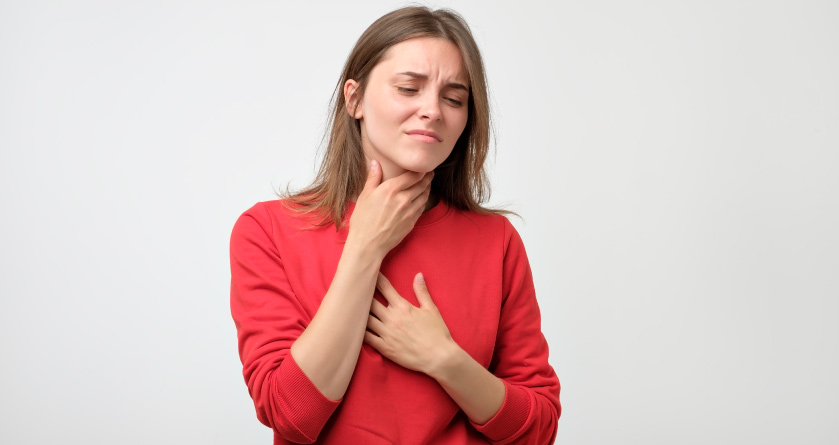 woman holding her throat during an allergic reaction at the dentist office