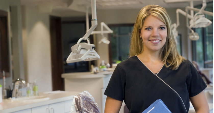 dental assistant smiles at a patient during dental assistant's recogniton week