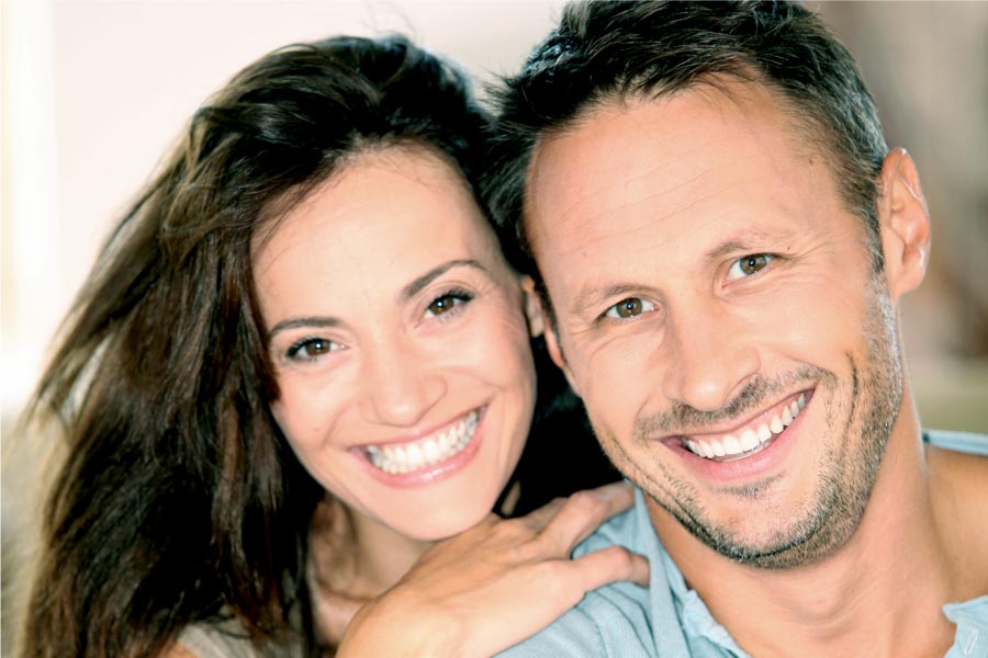 couple smile to show off their porcelain veneers