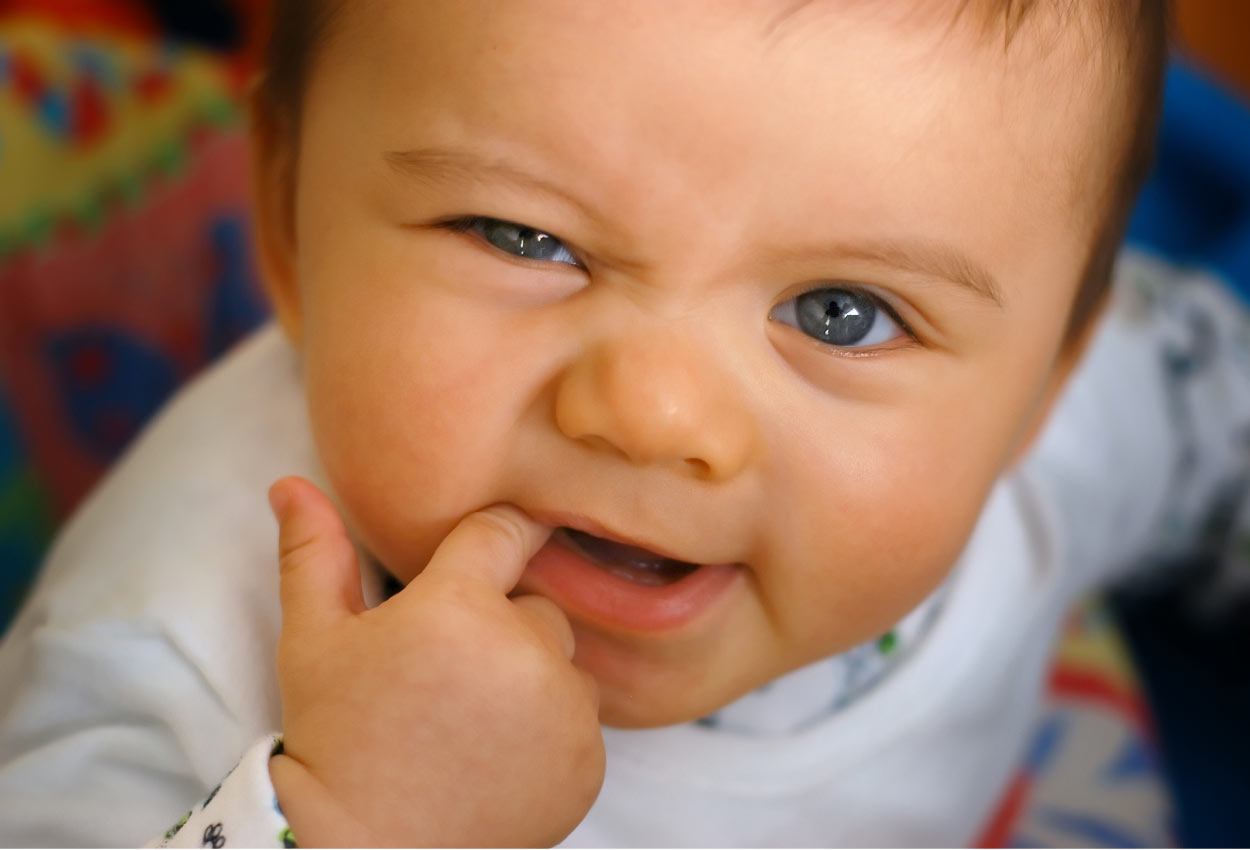 baby teething on an index finger