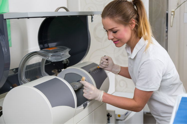 young female dental technician uses  same day crowns machine