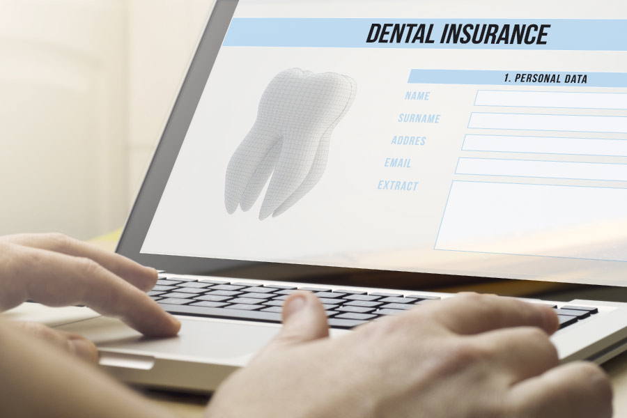 using a laptop computer to research dental insurance benefits