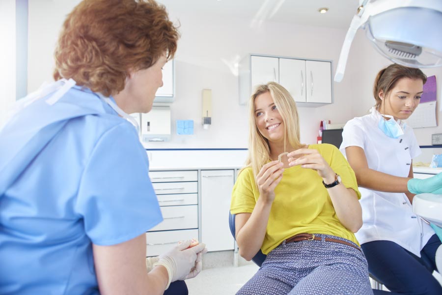 young woman learns about functional orthodontics at the dentist office